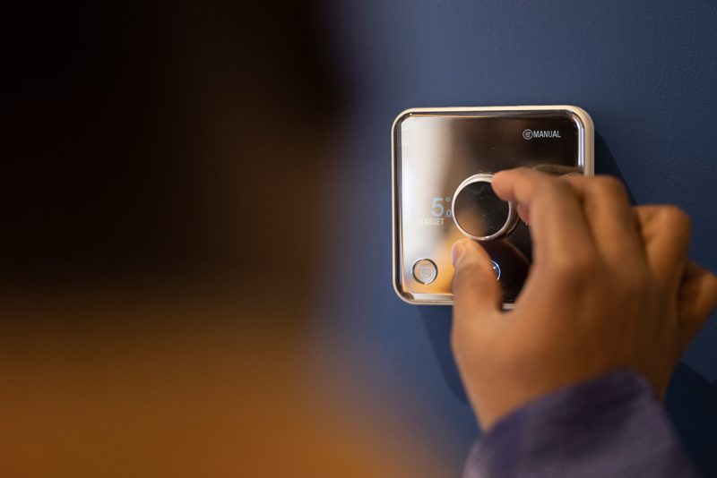 Man using thermostat at home